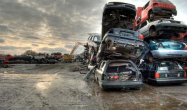 Scrapped cars piled on top of each other in scrap yard