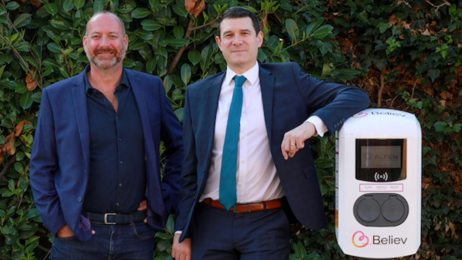 Believ CEO and North Northamptonshire Councillor stand next to a newly installed Believ charge point