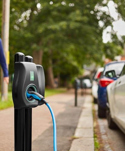 Man walks down path next to Connected Kerb on-street charge point