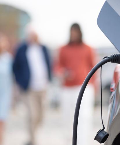 EV charging port, people out of focus in background