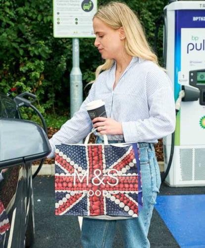 bp pulse charger at M&S store - lady holding M&S bag while charging car