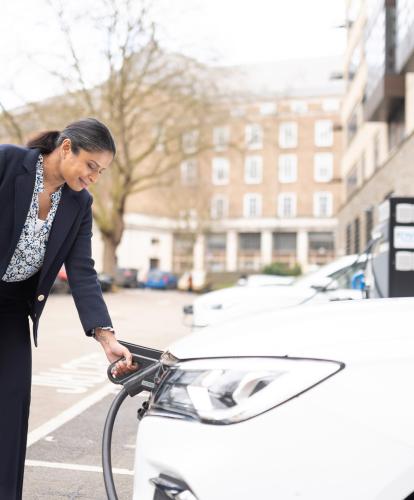 Business woman charging her EV at her office car park