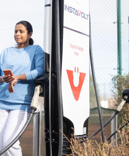 Woman charging her EV on a public charger