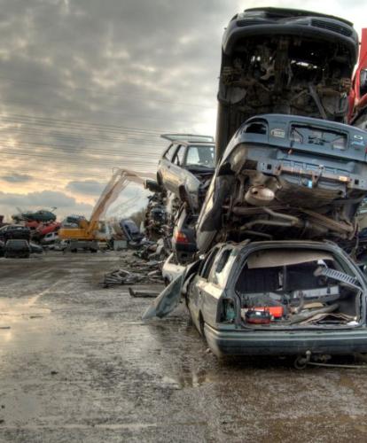 Scrapped cars piled on top of each other in scrap yard