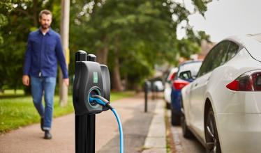 Man walks down path next to Connected Kerb on-street charge point