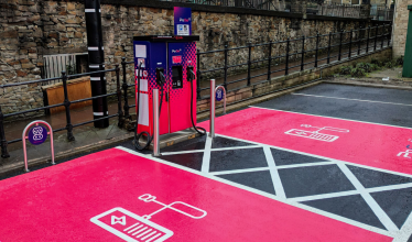 PoGo charge point in car park with pink EV parking bays