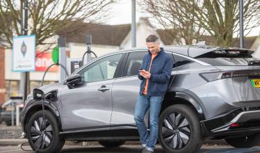 Man charges EV on supermarket car park while using Zapmap on his phone