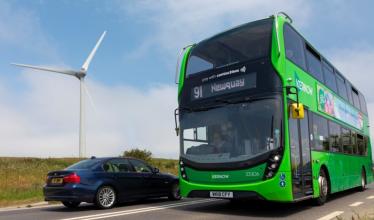 First bus in front of wind farm