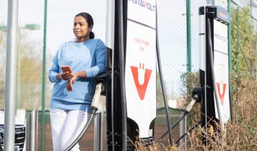 Woman charging her EV on a public charger