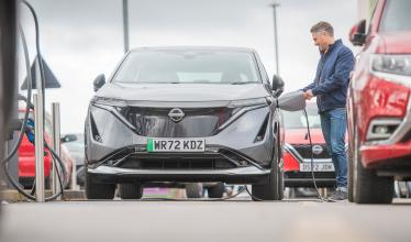 Woman charging her EV in public charger location