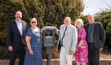Council members stand in front of Believ charge point in Pebble Beach car park